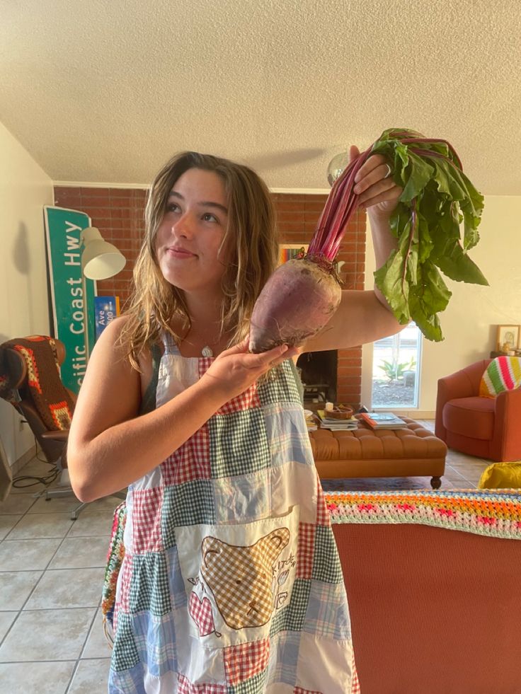 a woman holding up a bunch of vegetables