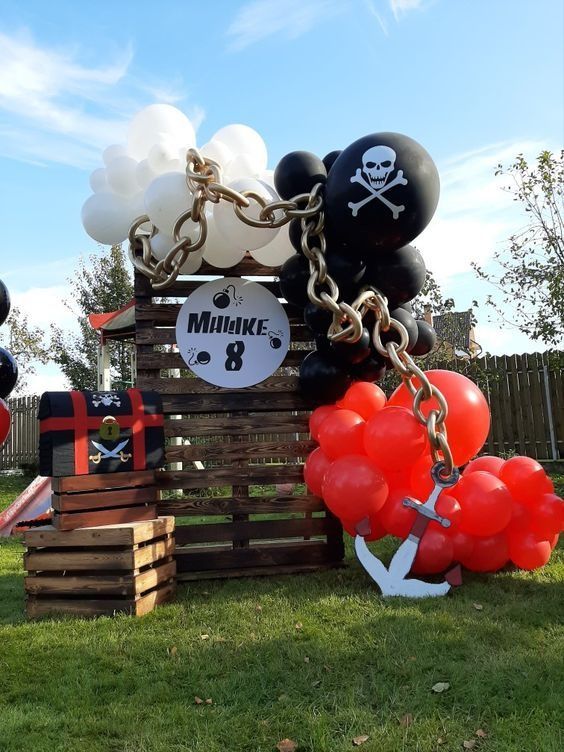 a pirate themed birthday party with balloons and decorations on display in the back yard,