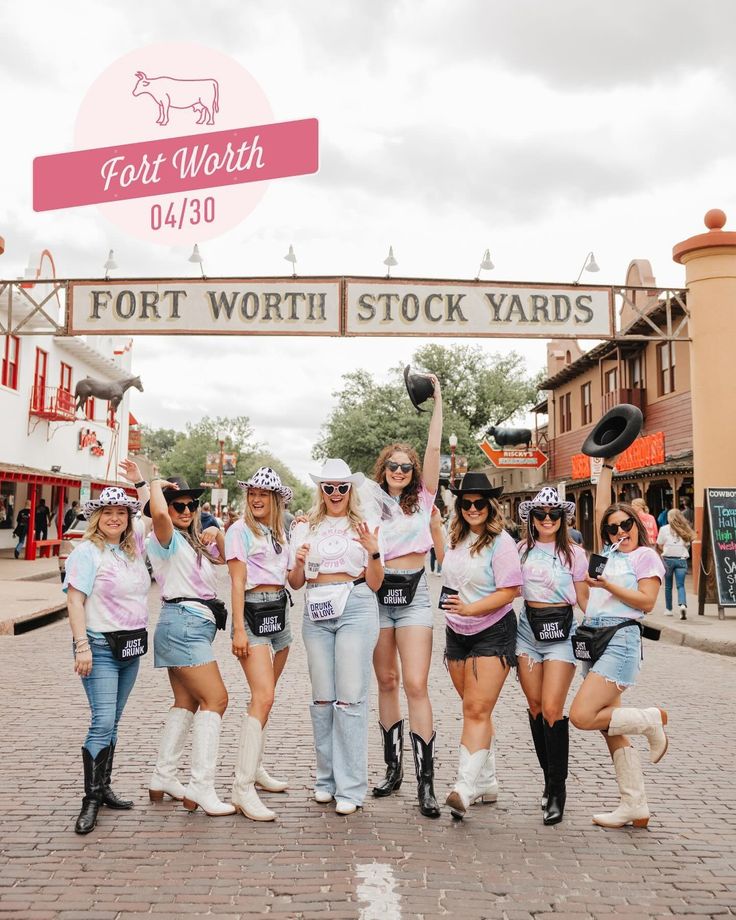 a group of young women standing next to each other under a sign that says fort worth stock yards