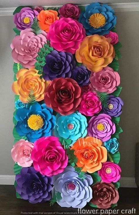 paper flowers are arranged in the shape of a letter made out of colorful paper flowers