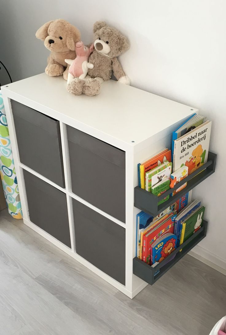 two teddy bears sitting on top of a white book shelf next to a toy bear