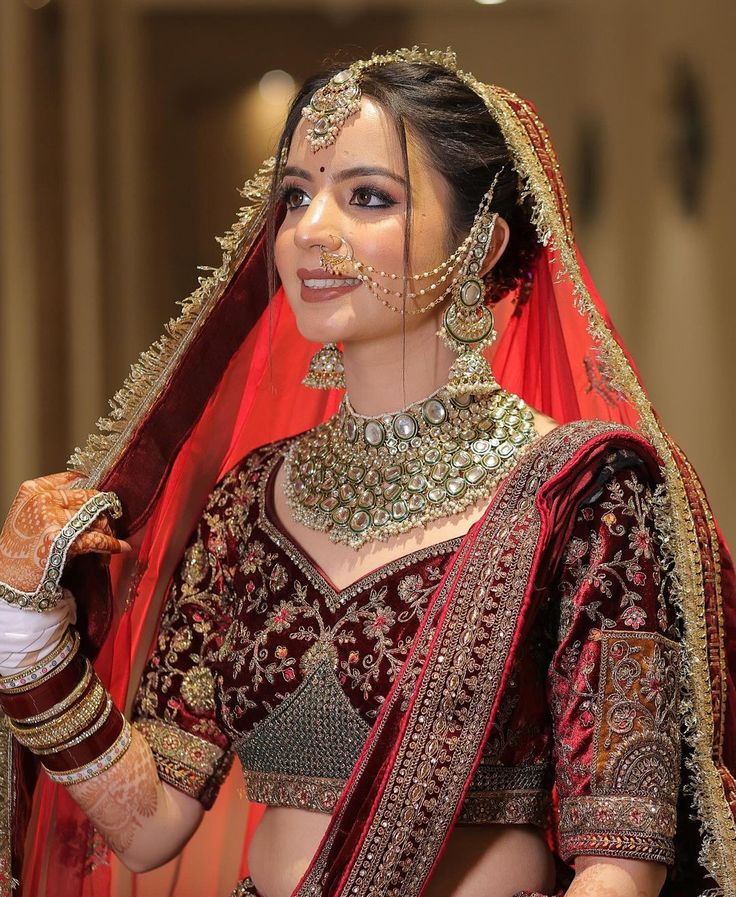 a woman in a red and gold bridal outfit