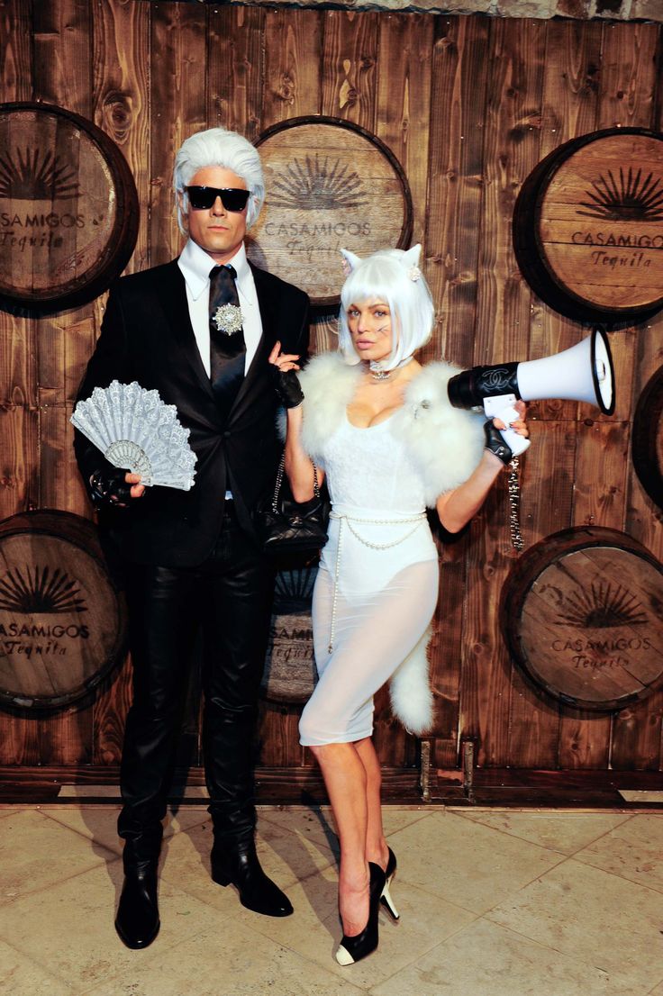 a man and woman dressed up in costumes standing next to each other, one holding a megaphone