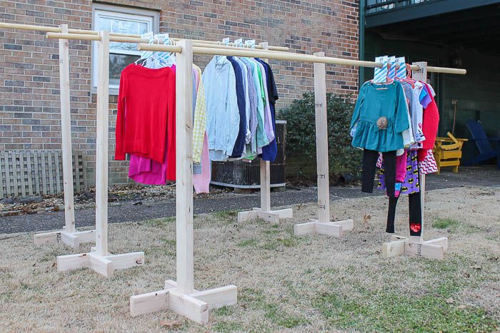 clothes are hanging on wooden poles in front of a brick building