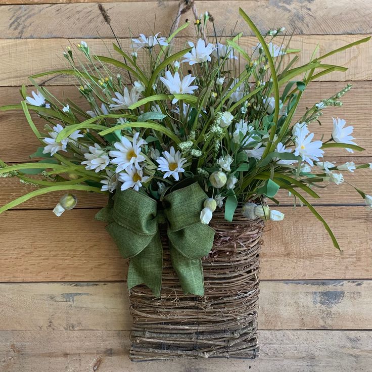 a basket filled with blue flowers sitting on top of a wooden floor next to a wall