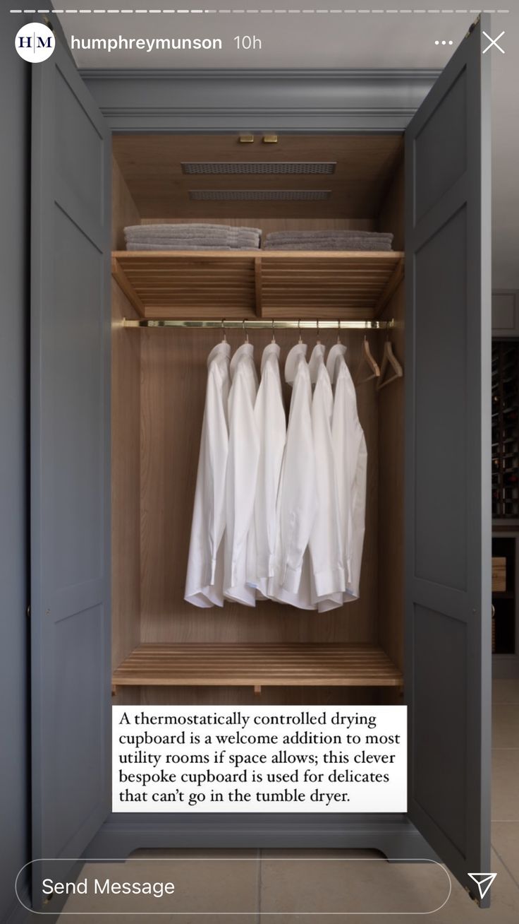 an open closet with three white shirts hanging on it