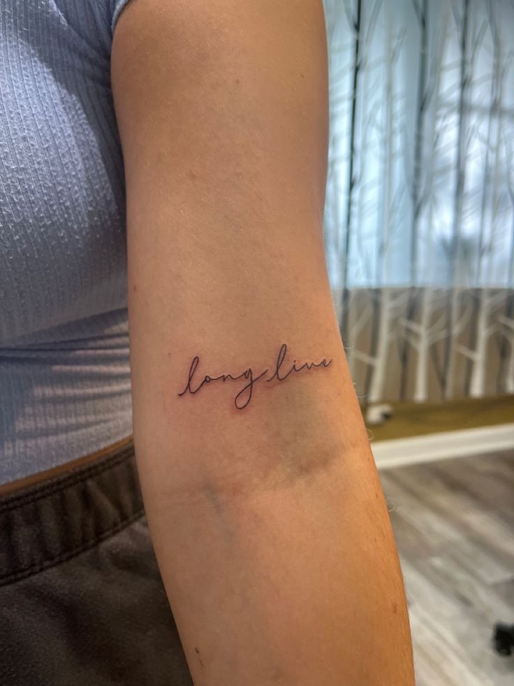 a woman's arm with the word love written on it and her name in cursive font