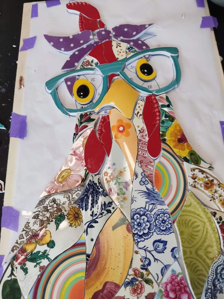 a paper cut out of a rooster wearing glasses and a hat with flowers on it