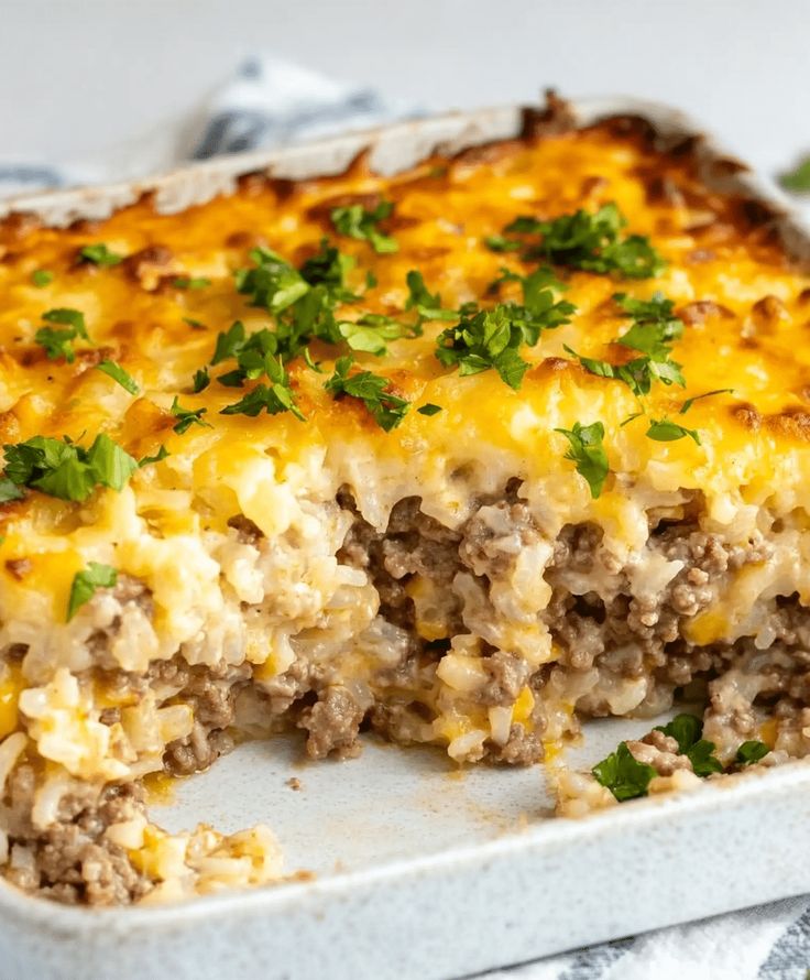 a casserole dish with meat, cheese and parsley in it on a white plate