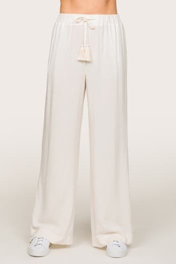 Crafted from a blend of linen and rayon, these breathable pants offer a luxurious drape and an incredibly soft hand feel. Designed for ultimate comfort, these high-rise pants feature an elastic waistband, a stationary tassel tie, and wide straight legs. With practical pockets and versatile styling options, they effortlessly transition from beach days to brunch outings, showcasing the epitome of laid-back elegance. Summer weight linen blend 29.75" inseam 14" high rise pant Straight, wide leg Full Summer Wide-leg Viscose Pants, Summer Viscose Wide-leg Pants, Casual Beige Viscose Bottoms, Wide Leg Rayon Lounge Pants, Summer High-waisted Wide Leg Viscose Pants, Summer Viscose Bottoms For Loungewear, Rayon Ankle-length Loungewear Bottoms, Rayon Ankle-length Loungewear Pants, Summer Pants With Loosely Fitted Hips In Viscose