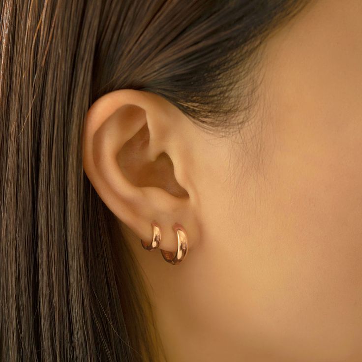 14K Solid Rose Gold small huggie earrings with a thick width. Perfect to wear alone or stacked with other huggies in our collection. 14K Rose Gold Hypoallergenic, lead and nickel free Width 3mm Inside Diameter:6mm, 7.5mm Weight: 0.8g, 0.9g Click close mechanism #ES034-6RG Gold Hoop Earrings Double Piercing, Good Huggie Earrings, 2 Ear Piercings Ideas Simple Gold, Mini Hoops Earrings, Small Gold Hoops Earrings, Gold Mini Hoop Earrings, Mini Earrings Gold, Sleek Gold Earrings, Rose Gold Huggie Earrings