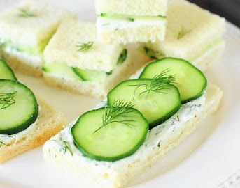 cucumber sandwiches are arranged on a white plate