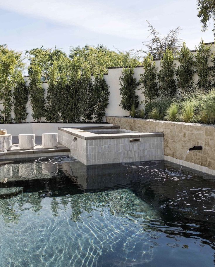 an outdoor hot tub in the middle of a patio with string lights hanging above it