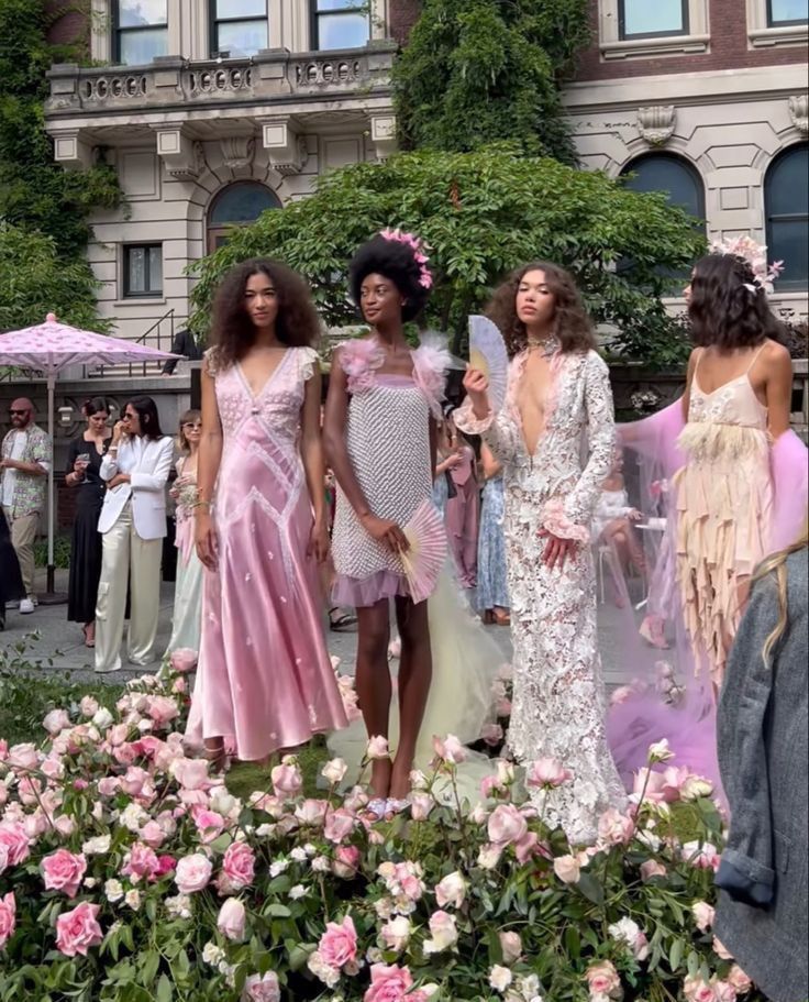 the models are standing in front of pink flowers