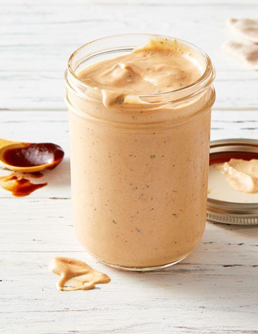 a jar filled with peanut butter sitting on top of a table next to a spoon