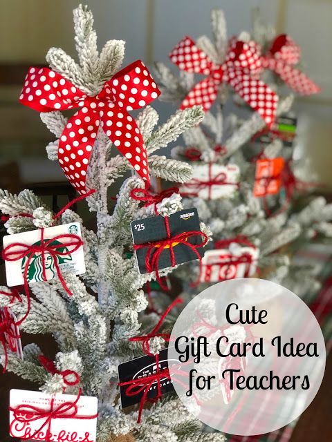 a white christmas tree with red bows and gift cards on it, sitting in front of a window