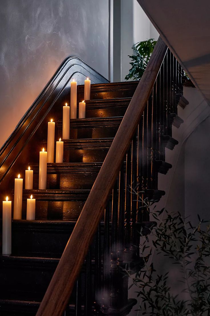 candles are lit on the stairs in front of an open door