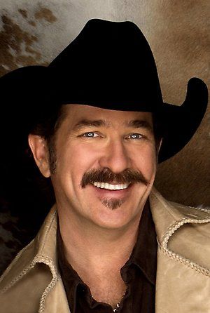 a man in a cowboy hat smiling for the camera