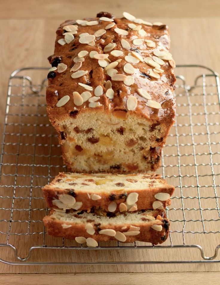 a loaf of bread sitting on top of a metal rack next to a slice of cake