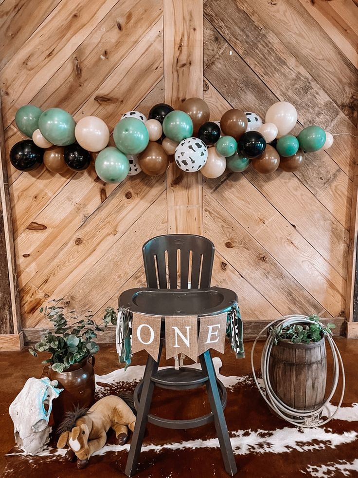 a chair sitting on top of a wooden floor next to a wall with balloons hanging from it