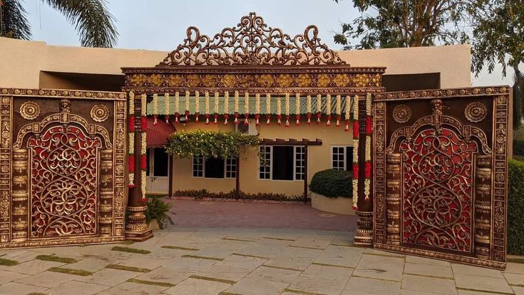 an elaborately decorated entrance to a house with red and gold decorations on the doors