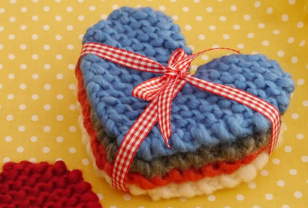 a knitted heart sitting on top of a red and white polka dot table cloth