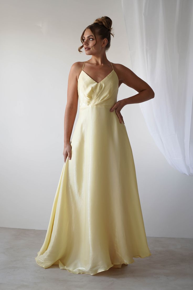 a woman in a yellow dress posing for the camera with her hands on her hips