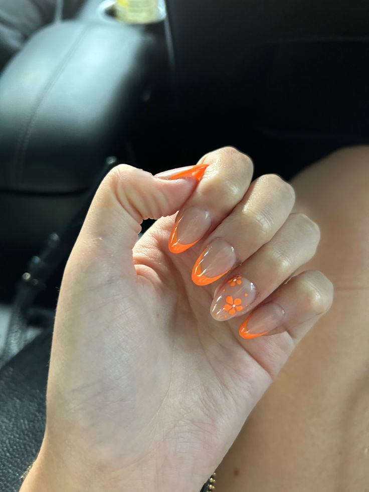 Orange Flower Acrylic Nails, Orange Flower French Tip Nails, Orange And White Almond Nails, Light Orange Nails With Design, Orange French Tip With Design, Orange Oval Acrylic Nails, Orange French Tip Nails With Flowers, Orange Nails With White Flowers, Orange Graduation Nails