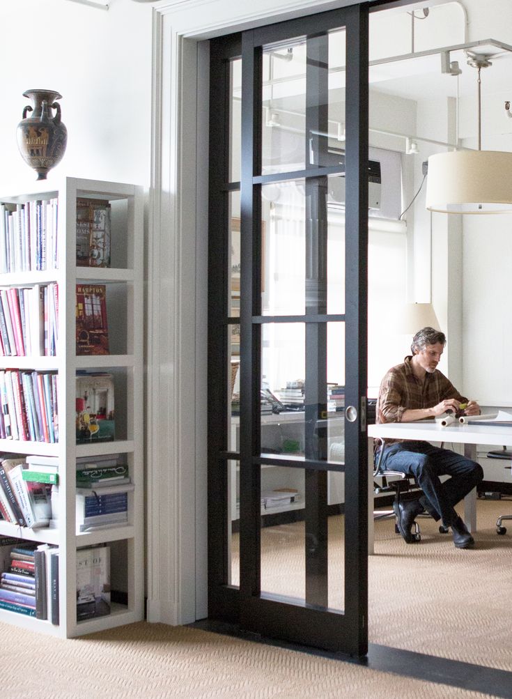 a man sitting at a table in front of a book shelf