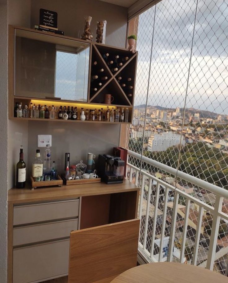 there is a small bar on the balcony with bottles and glasses in front of it