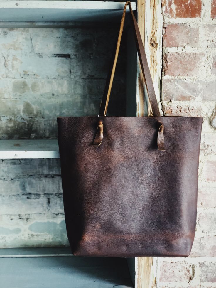 Looking for something deep and rustic? Here’s your dream bag for all day, every day. With a large interior pocket and adjustable knotted straps you’re good to go. Optional snap closure. 15” w by 14” h by 4” Rustic Shoulder Bag With Leather Handles For Travel, Brown Crossbody Bag With Rolled Handles, Everyday Bucket Shoulder Bag With Rolled Handles, Rustic Brown Bag For Everyday Use, Rustic Bags With Leather Handles For Everyday, Rustic Bags With Leather Handles For Daily Use, Rustic Everyday Tote Bag, Rustic Brown Tote Bag, Rustic Crossbody Bag For Everyday Use