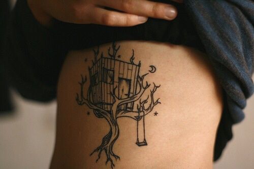 a person with a tree house tattoo on their thigh