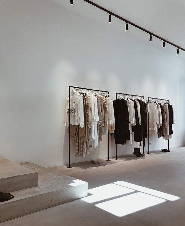 an empty room with clothes hanging on racks