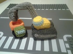 two crocheted objects sitting on top of a gray table next to each other