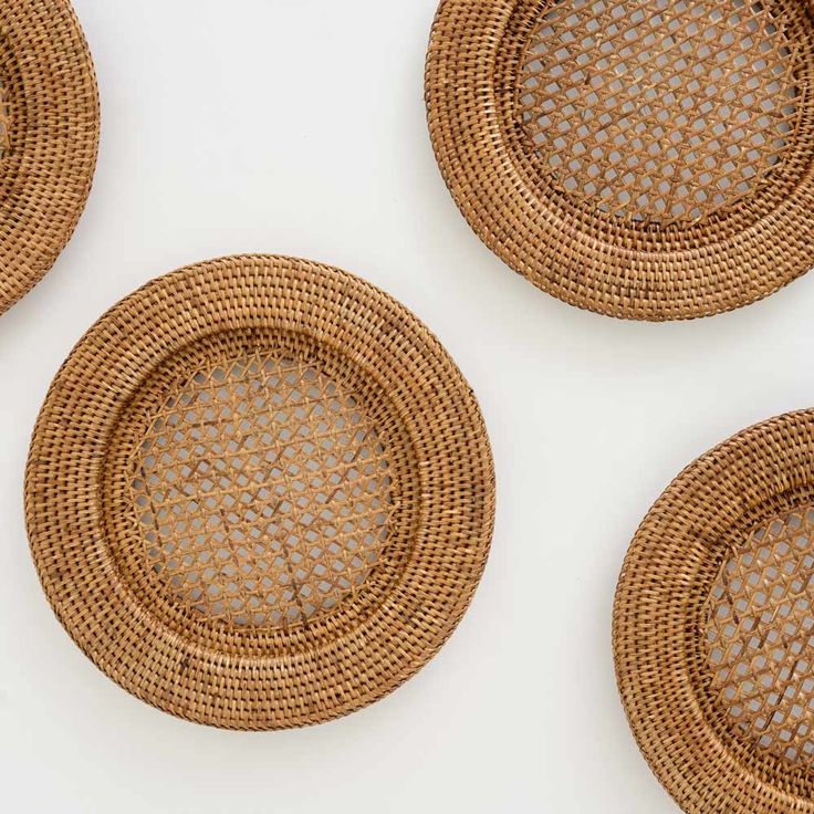 four woven coasters are arranged in the shape of circles on a white table top