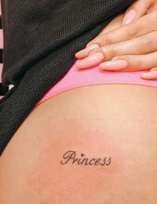 a pregnant woman's stomach with the word princess written on her lower back tattoo