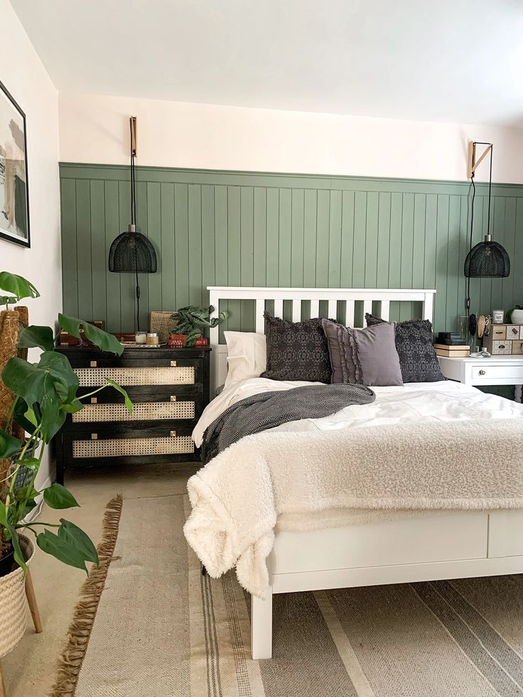 a white bed sitting in a bedroom next to a green wall