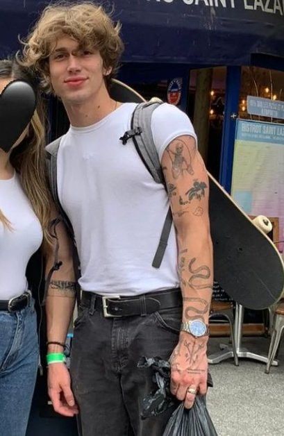 a man and woman standing next to each other with skateboards on their shoulders in front of a store