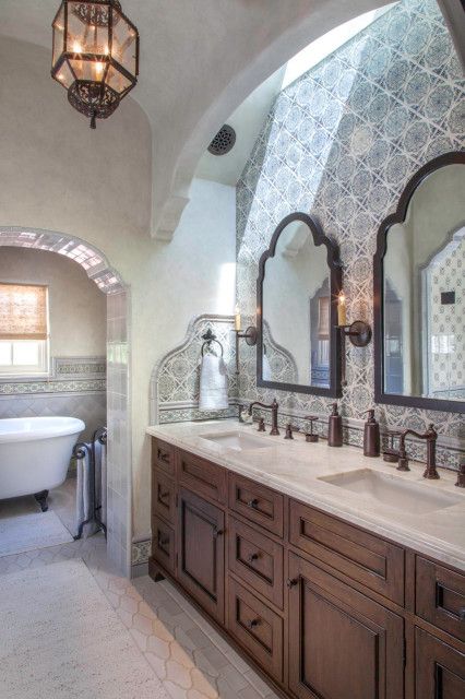 a bathroom with two sinks and a bathtub in the middle, along with a chandelier hanging from the ceiling