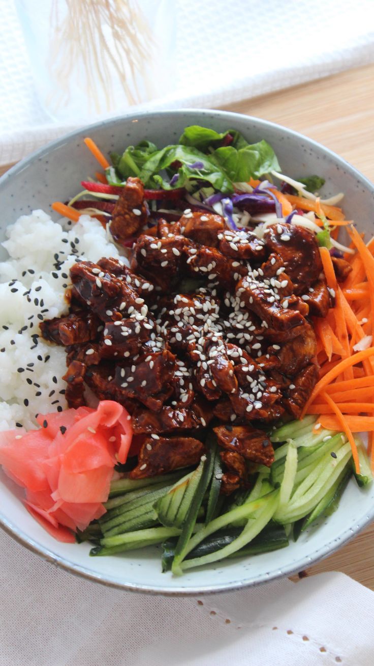 a bowl filled with meat, rice and vegetables