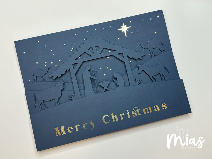 a merry christmas card with the nativity scene in blue and gold on it's front