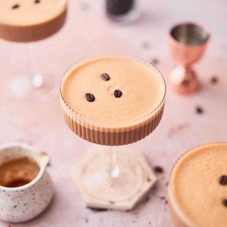 two desserts on a table with chocolate chips and coffee in the cups next to them