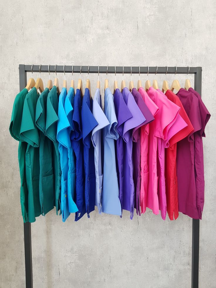 several different colored shirts hanging on a rack