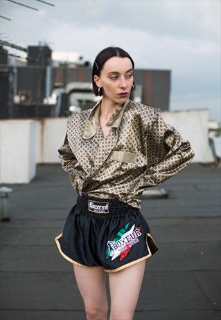 a woman standing on top of a sidewalk wearing shorts