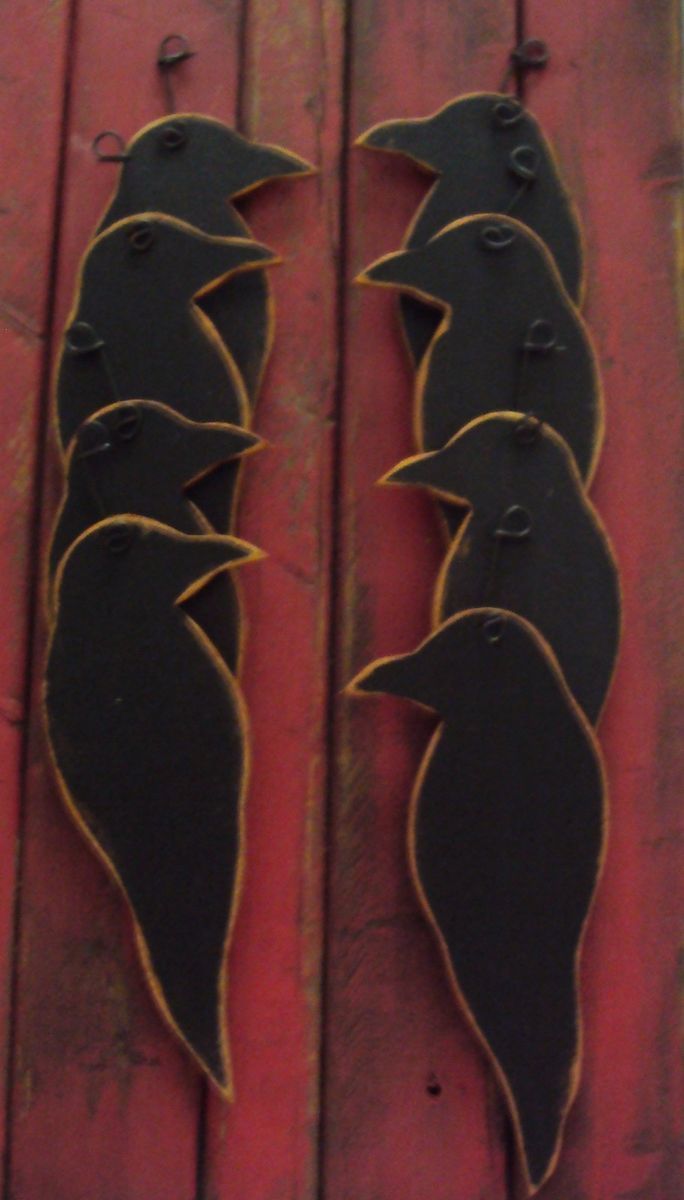 three metal birds are on the side of a red door