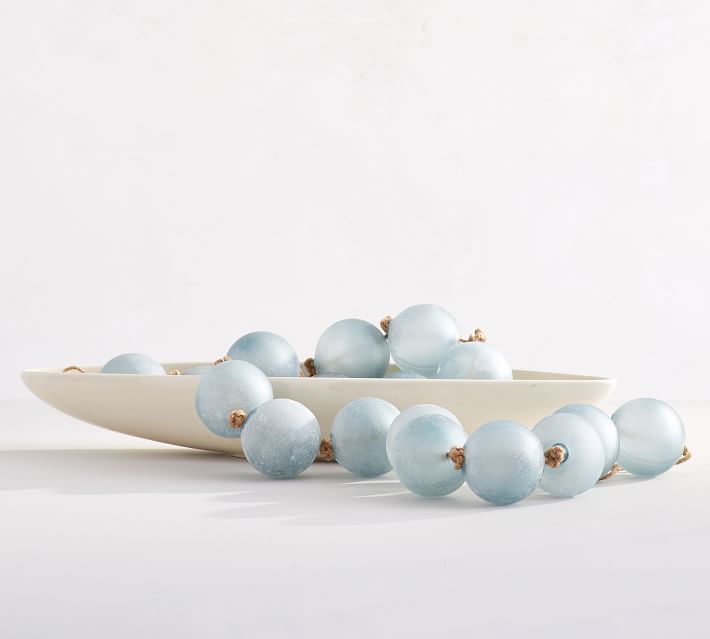 a white bowl filled with blue glass balls