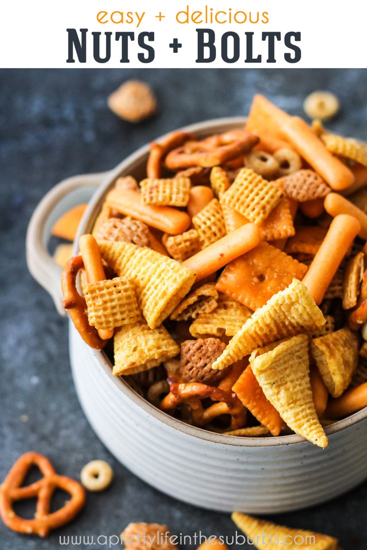 a bowl full of cheesy snack mix with pretzels and crackers