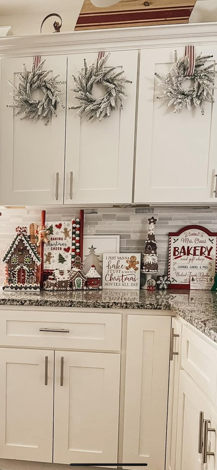 a kitchen with white cabinets and christmas decorations