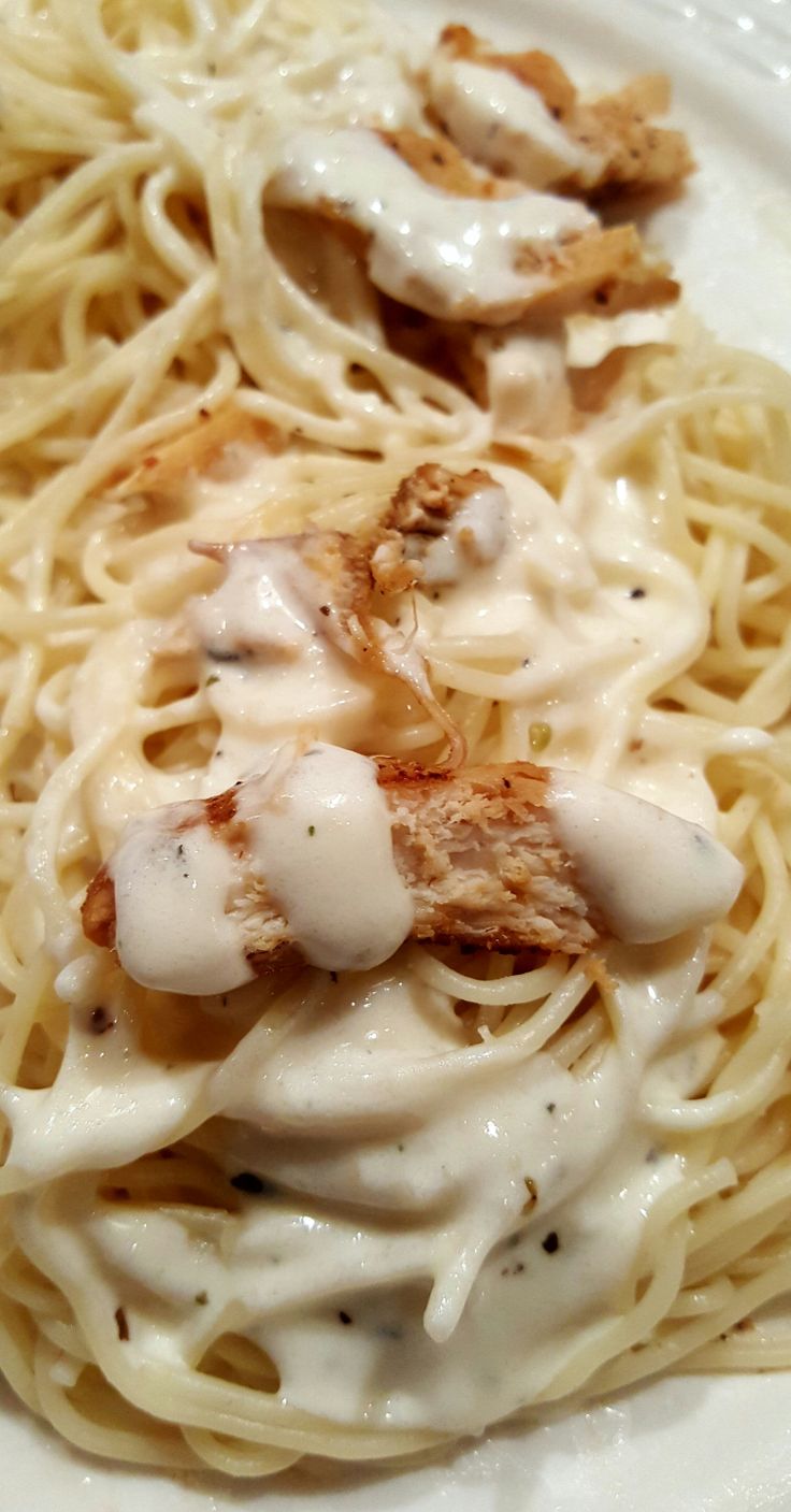 a white plate topped with pasta covered in sauce