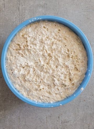 a blue bowl filled with batter sitting on top of a table